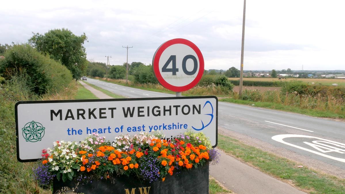 Market Weighton - the heart of east Yorkshire road sign with view of countryside behind
