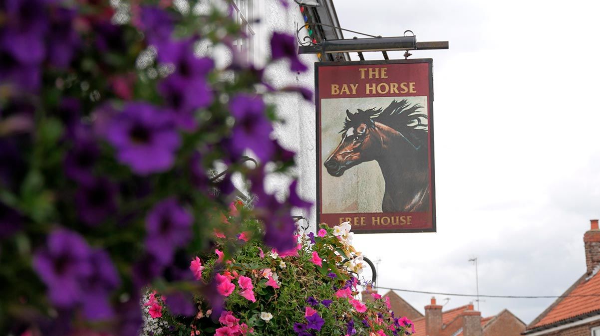 The Bay Horse pub sign with flowers in foreground Market Weighton