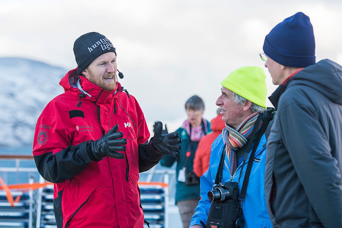 Tour guide and passengers on Norwegian coastal voyage